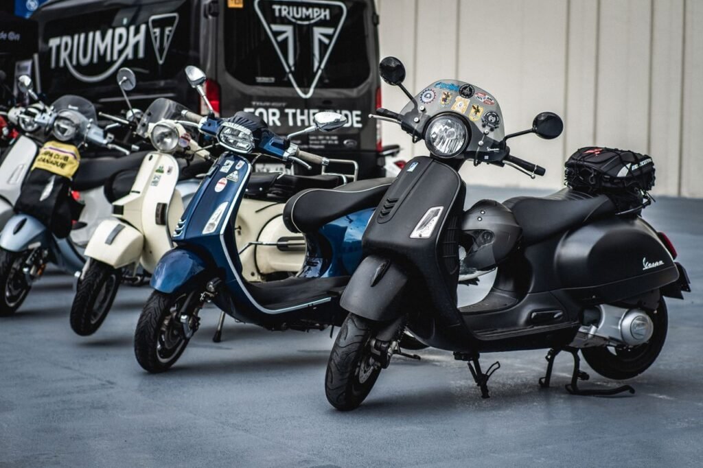 A lineup of classic Vespa scooters parked outdoors, showcasing vintage style and Italian design.
